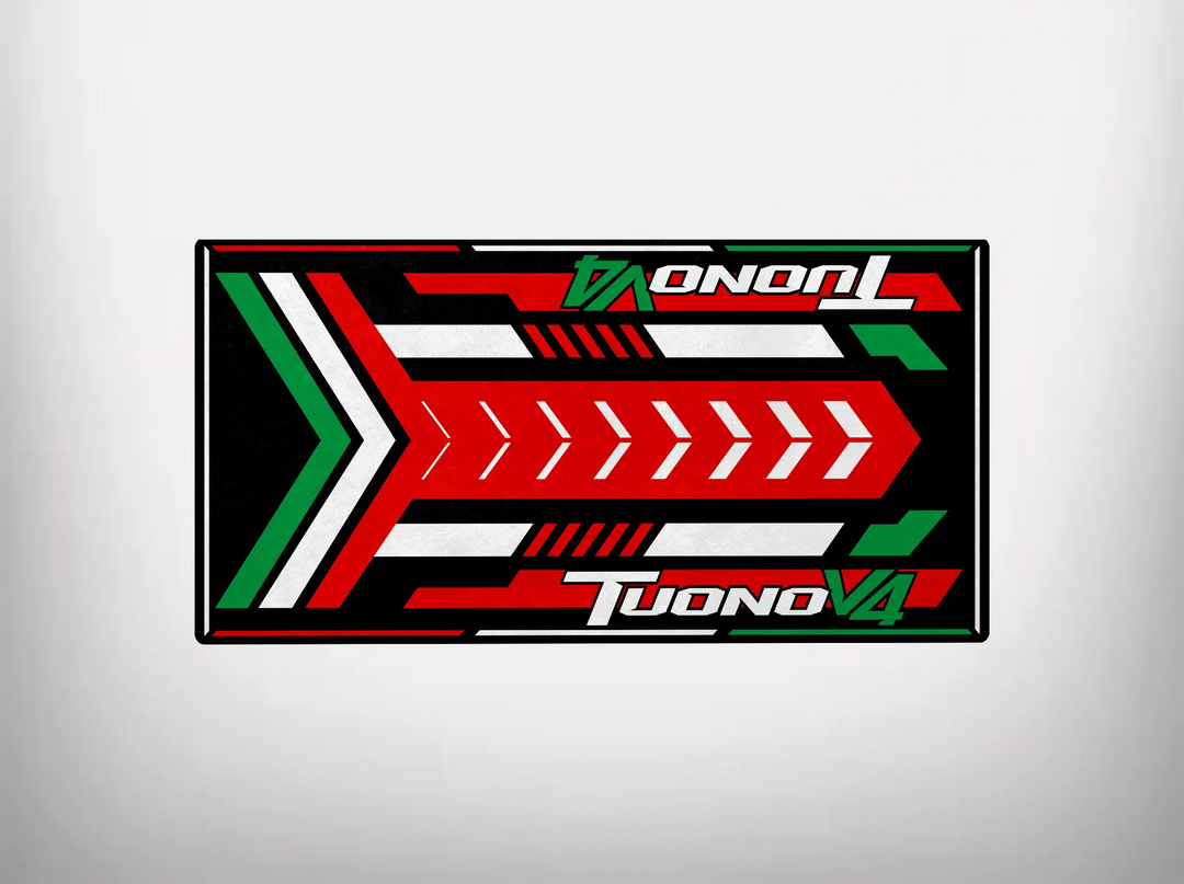 Rectangular graphic mat by Motorcycle Pit Mat with bold red, white, green, and black geometric patterns for the Tuono V4 motorcycle. It features arrow designs and the words TUONO V4 in a dynamic, angled font on both sides, reminiscent of racing graphics.