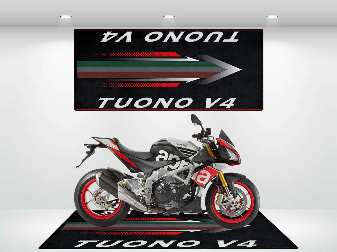 A sporty Motorcycle Mat for the Tuono V4 with a black, white, and red design features prominently in the showroom. Beside it, a banner highlights TUONO V4. The sleek motorcycle it supports has vibrant red rims that catch every eye.