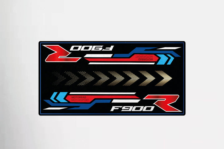 The Motorcycle Pit Mat sports bold red, blue, and white graphics with F900 R and MOTORRAD MOTORSPORT text. Designed with stylized arrows and dynamic lines on a black background, this matches any motorbike mat or motorcycle mat setup seamlessly.