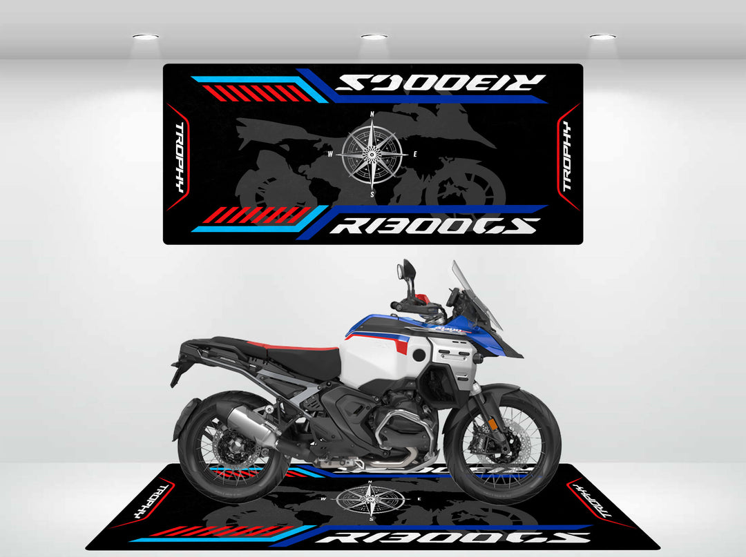 A motorcycle with a blue, white, and black color scheme is displayed on a Motorcycle Pit Mat. The background mirrors the mats design featuring the model name R1300 GS Trophy.