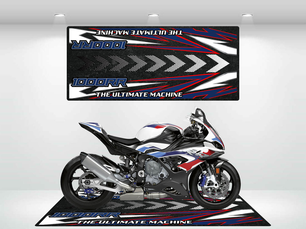 A sporty S1000RR rests on a Motorcycle Pit Mat, highlighting its sleek design. The mat and backdrop feature bold black, white, red, and blue graphics with text stating THE ULTIMATE MACHINE.