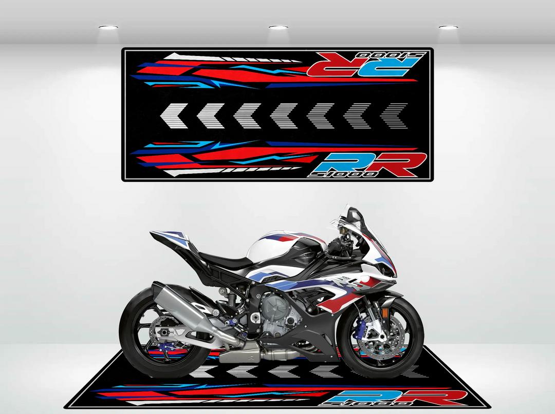 A sleek, sporty motorcycle is displayed indoors on a Motorcycle Pit Mat designed as the Motorcycle Mat for S1000RR (Bestseller), featuring dynamic red, blue, and white graphics that extend to the backdrop, enhancing a modern racing theme.