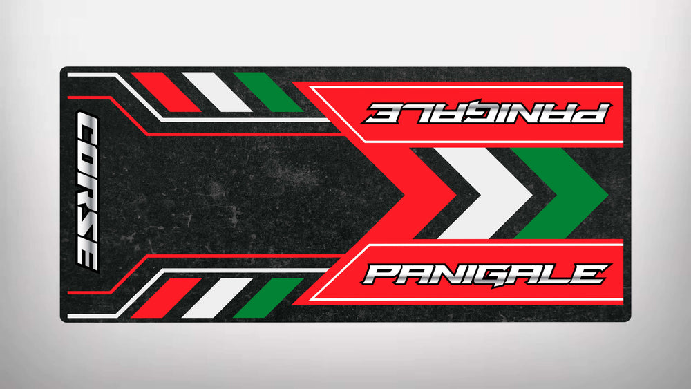 The Motorcycle Pit Mat brand offers the Motorcycle Mat for Panigale with a stylish design featuring red, green, and white stripes. It showcases CORSE on the left and PANIGALE upside down on a textured black background, perfect for adding flair to any motorbike enthusiasts space.