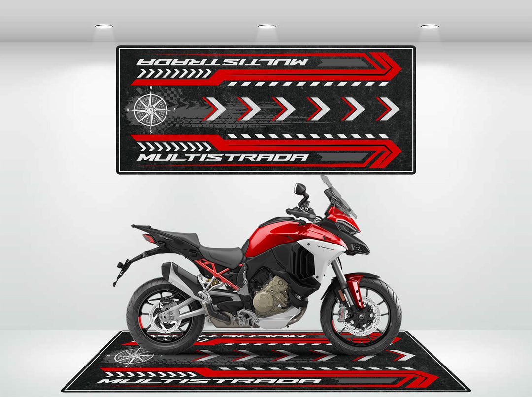 A red and black motorcycle sits in a bright showroom on a Motorcycle Pit Mat. The space is adorned with matching decor featuring red and white arrows and MULTISTRADA in large letters.