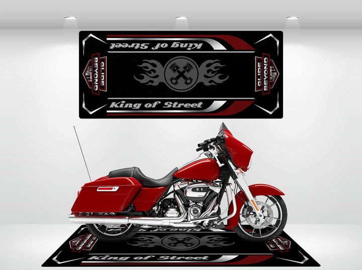 A red motorcycle sits on a vibrant Motorcycle Pit Mat, designed as a Motorcycle Mat for King of Street - Glide Beyond Limits with flame graphics. The wall reflection creates a mirrored effect that amplifies its bold look.