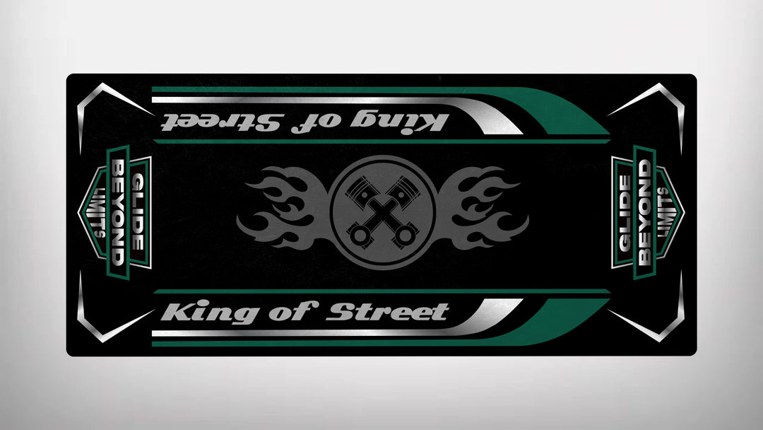 A black skateboard deck inspired by the Motorcycle Pit Mats motorbike design features crossed wrenches and flame patterns. King of Street and Glide Beyond Limits in bold white and green add a thrilling ride vibe.