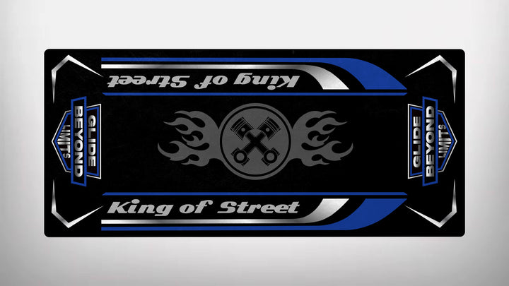 The Motorcycle Pit Mats Motorcycle Mat for King of Street - Glide Beyond Limits features a black rectangular design with King of Street in stylish script, accompanied by flaming pistons. Blue, white, and silver accents enhance this dynamic piece, perfect for any motorbike mat collection.