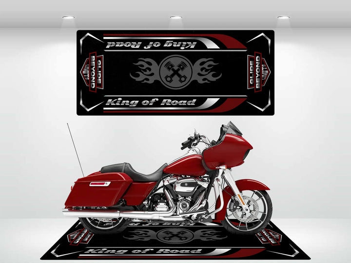 A red motorcycle rests on a sleek Motorcycle Pit Mat, Motorcycle Mat for Road Glide, adorned with fiery flames and crossed tools. Above, a matching durable wall hanging mirrors the design, enhancing the striking scene.