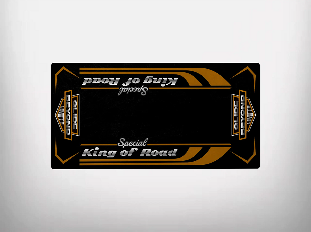 The Motorcycle Pit Mat features a rectangular black design with gold and white graphics, reading King of Road Special in the center, flanked by globe logos. Its Harley Davidson aesthetic and symmetrical pattern make it versatile for use and display.