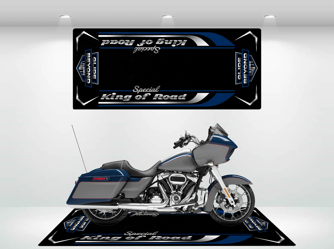 A blue and silver Harley Davidson motorcycle is parked on a Motorcycle Pit Mat, titled Motorcycle Mat for Road Glide Special in stylized text. A matching sign above it enhances the vibrant indoor display, adding flair to its sleek presentation.