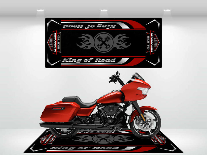 A red motorcycle is showcased indoors against a white wall, with Harley Davidsons Motorcycle Mat for Road Glide beneath and above it. The durable black mat features red, white, and gray designs with the text King of Road alongside images of crossed wrenches and flames.