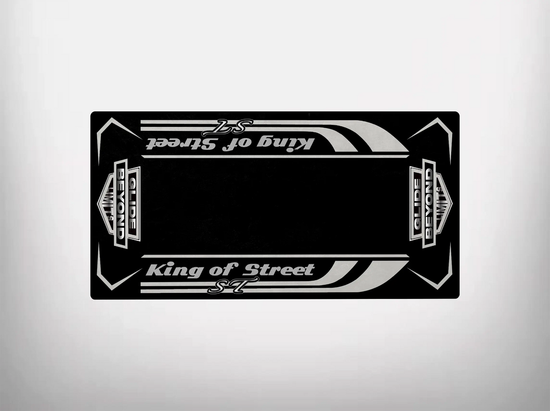 The Motorcycle Pit Mats Street Glide ST motorcycle mat showcases a sleek design with a black rectangular card featuring stylized white King of Street and S7 text. Decorative stripes and ornate elements evoke Harley Davidson aesthetics against a plain light gray background.