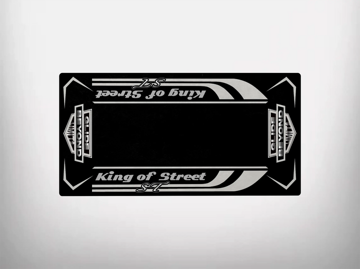 The Motorcycle Pit Mats Street Glide ST motorcycle mat showcases a sleek design with a black rectangular card featuring stylized white King of Street and S7 text. Decorative stripes and ornate elements evoke Harley Davidson aesthetics against a plain light gray background.