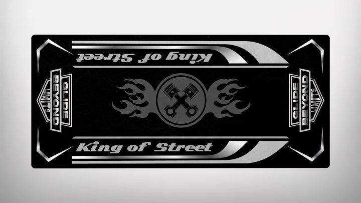 The Motorcycle Pit Mat Motorcycle Mat for King of Street - Glide Beyond Limits has a black banner with the text King of Street and Guide Beyond Limits, featuring two crossed wrenches in a flame pattern, accented with silver and white, against a motorcycle garage mat-themed background.