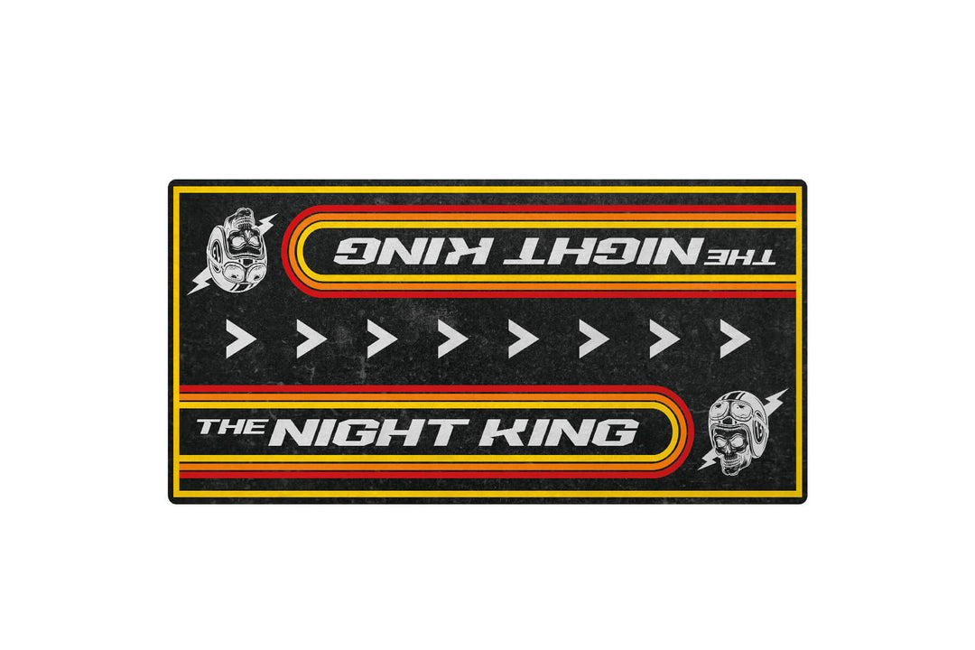 The Motorcycle Pit Mats Night King design features THE NIGHT KING mirrored, helmet graphics on each side, and a black base with red and yellow borders. White arrows point right, making it ideal for any motorcycle garage.