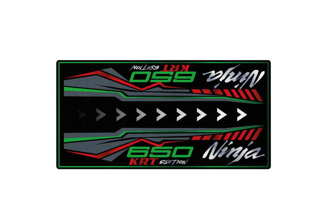 A stylized graphic with white, green, and red text on a black background reads Ninja 650 KRT Edition with white arrows and dynamic lines implying speed—ideal for enhancing any Motorcycle Pit Mat or garage decor.