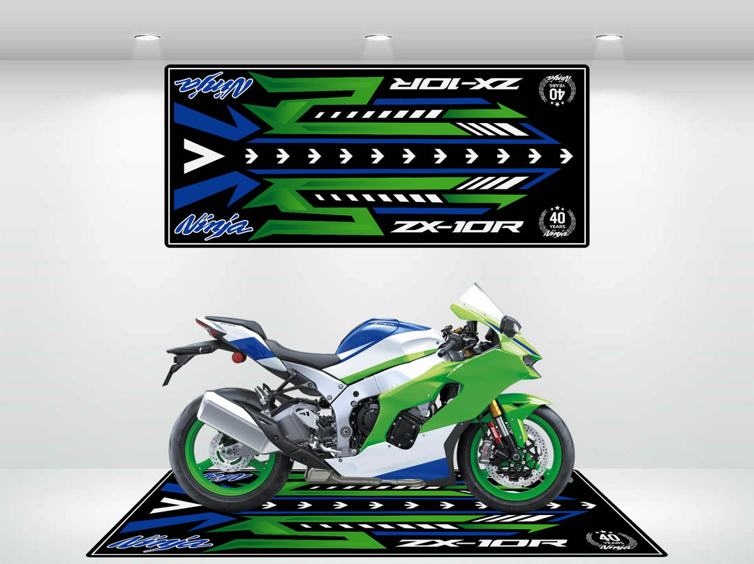 In a showroom, a green and blue motorcycle sits on a bold Motorcycle Pit Mat with angular designs. Above, a matching graphic decorates the wall, showcasing Ninja and ZX-10R from the Motorcycle Mat for Ninja ZX-10R 40th Anniversary collection.