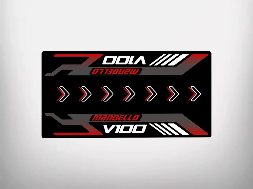 The Motorcycle Pit Mat for Mandello V100 Special is a rectangular graphic with a black background, featuring Mandello V100 in bold red and white letters. White arrows suggest motion like a motorbike mat design and red and white lines on the edges echo motorcycle floor mat style.