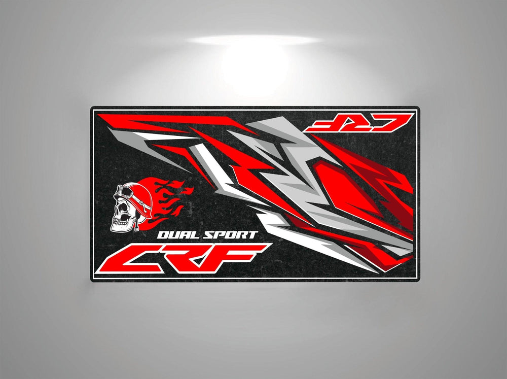 This Motorcycle Pit Mat for Honda CRF features an abstract red, black, and gray design with a helmeted skull and flames. The text Dual Sport CRF appears on the left side, J27 on the top right, all set against a gradient background.