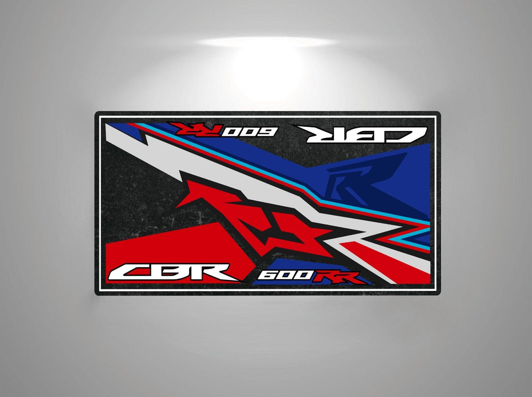 The Motorcycle Pit Mat for the Honda CBR600RR features an abstract design with bold, angular red, white, blue, and black shapes. The text CBR 600 RR and 009 is included in a dynamic composition that evokes the thrill of the open road.