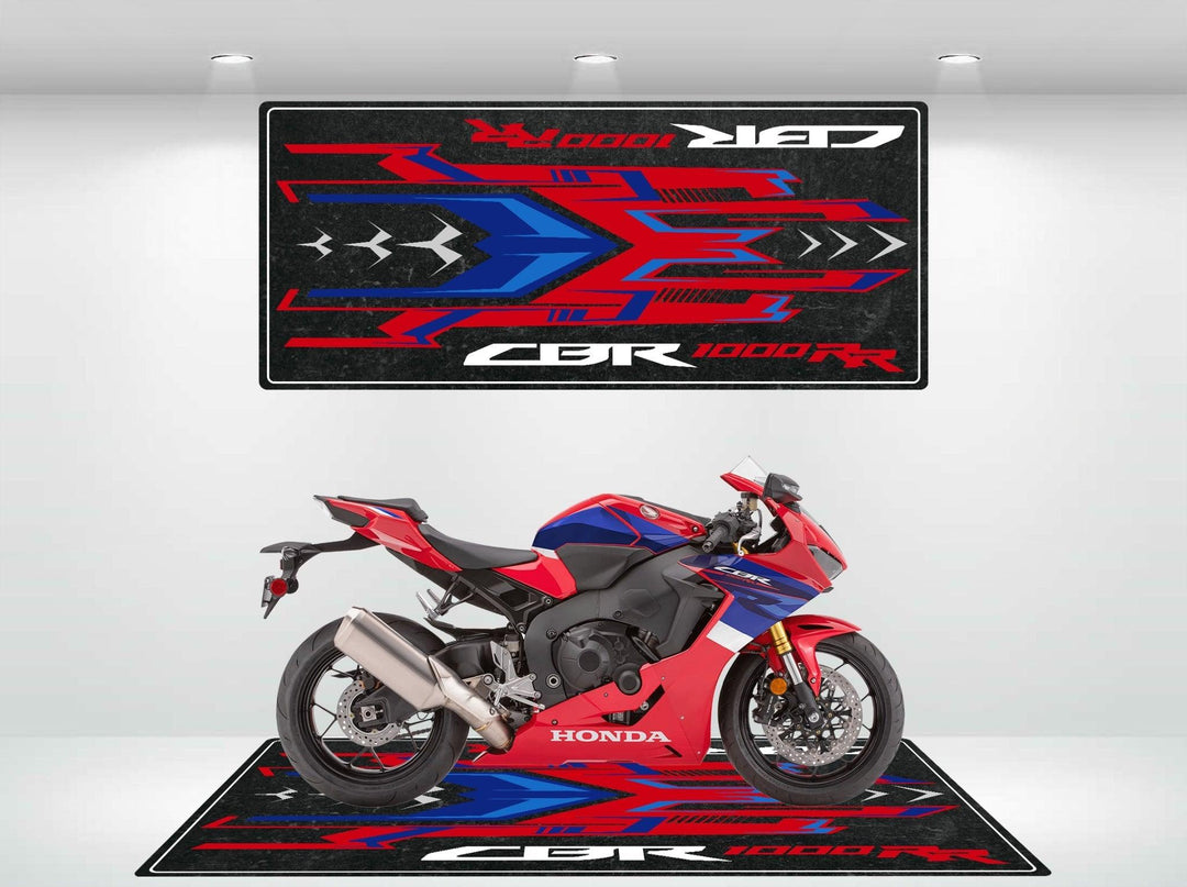 A red and blue sport motorcycle is parked on the Motorcycle Pit Mat for Honda CBR1000RR, showcasing bold geometric patterns with CBR 1000RR text in a mix of red, blue, and black against a white background.