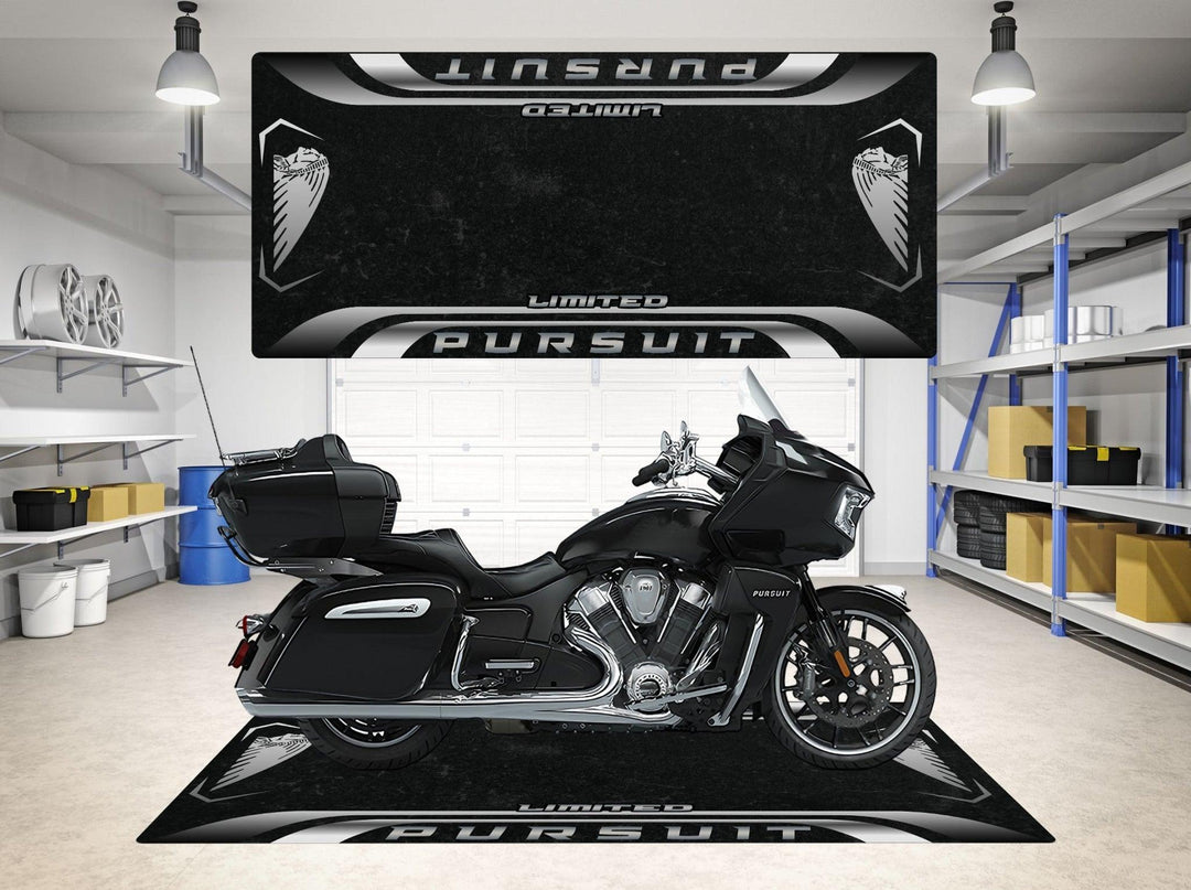 A black motorcycle is parked in a tidy garage on a Motorcycle Pit Mat for Indian Pursuit Limited. Shelving units with boxes and a helmet are in the background, while the floor mat and wall display matching sleek designs.