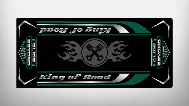 The rectangular Motorcycle Pit Mat features King of Road and Glide Beyond Limits in bold, with flaming pistons at the center. The symmetrical design uses black, silver, green, and white colors. Perfect as a motorcycle floor mat.