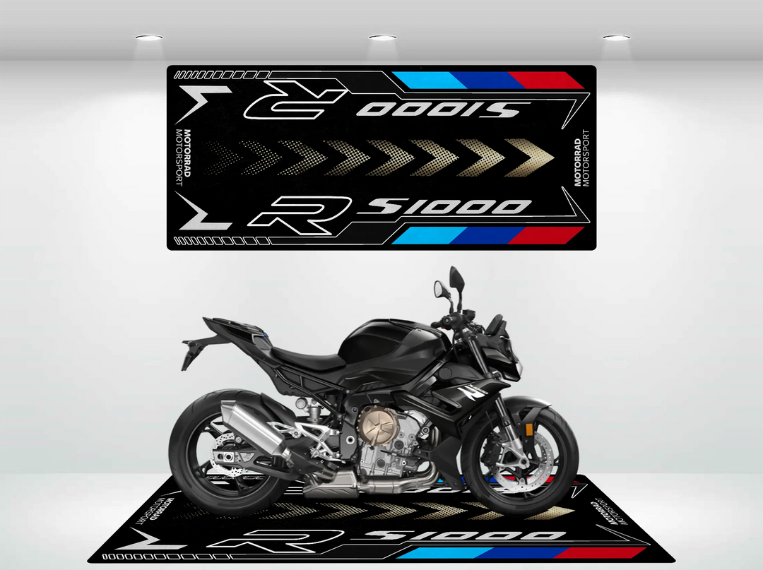 A sleek black motorcycle is showcased on a Motorcycle Pit Mat, specifically the Motorcycle Mat for S1000R. The mat features racing themes in black, silver, blue, and red. In the background is a R 1000 S design. Excellent lighting accentuates the bikes details.