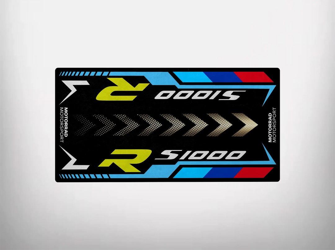 A rectangular sticker design with S1000R in bold white and yellow on black, featuring blue, red, and white geometric accents. It adds a sporty touch to your Motorcycle Pit Mat for S1000R and features Motorrad Motorsport on both ends for extra flair.