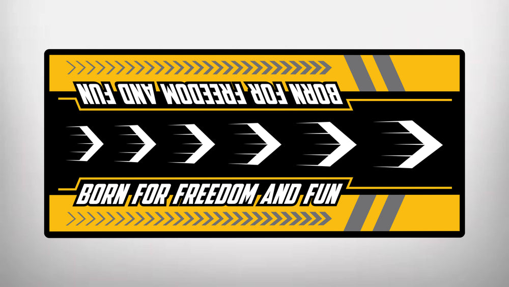 The Motorcycle Pit Mat for Scrambler features a bold design with yellow and black arrows, Born for Freedom and Fun text in white (repeated upside down), and striking chevron patterns with diagonal stripes.