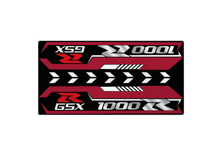 A rectangular motorcycle mat with red, black, and silver colors features bold white text and numbers like XS9, G5X, and 1000. Right-pointing arrows and geometric shapes enhance it, perfectly complementing your Suzuki GSX-R1000R 2025 garage aesthetic. Brand: Motorcycle Pit Mat.