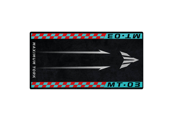 On a dark backdrop, an arrow design with red and turquoise borders evokes motorcycle speed on the Yamaha MT-03 mat. MAXIMUM TORK appears on the left, MT-03 at the top, and EO.LW in the bottom right. This is part of Motorcycle Pit Mats collection.