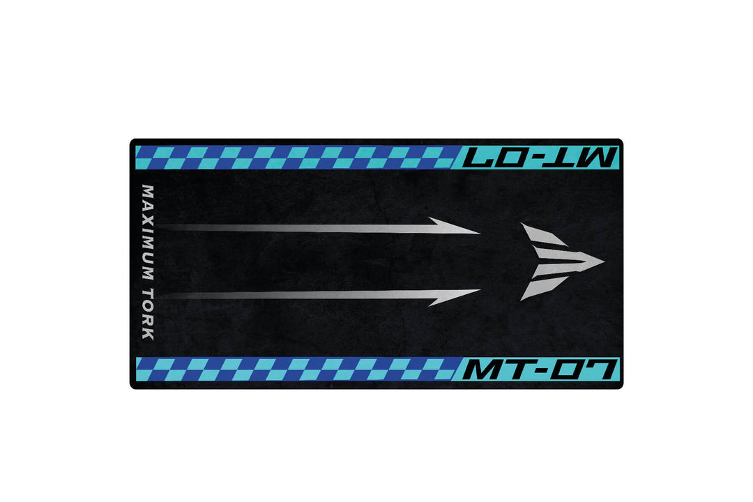 The Motorcycle Pit Mat for Yamaha MT-07, in black, features three white arrows with blue accents. MAXIMUM TORQUE and MT-07 are emblazoned on left and right respectively, with a vehicle emblem-style logo—ideal for any motorcycle garage.