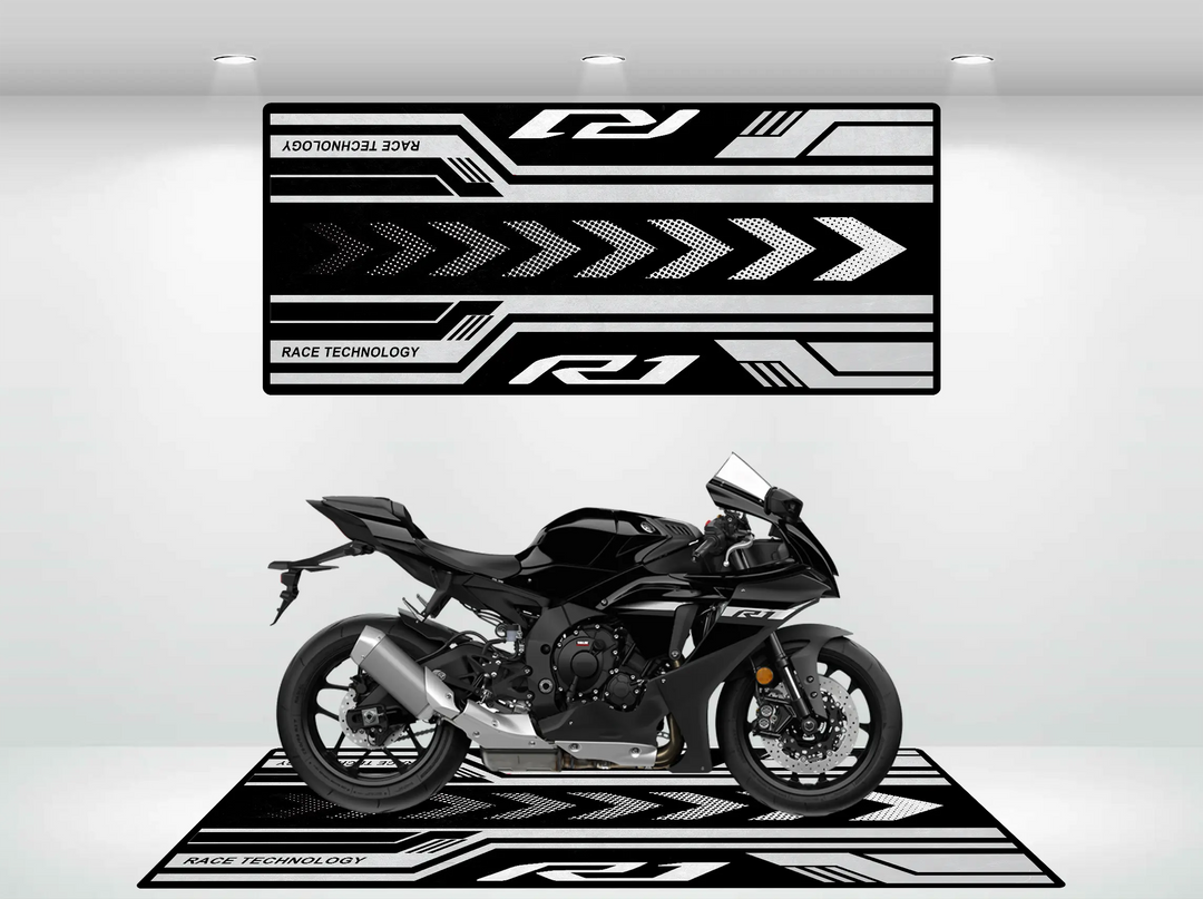 A Yamaha R1 2025 Design motorcycle rests on a sleek Motorcycle Pit Mat in a minimalist showroom, showcasing black and white graphics with arrows and Race Technology text.