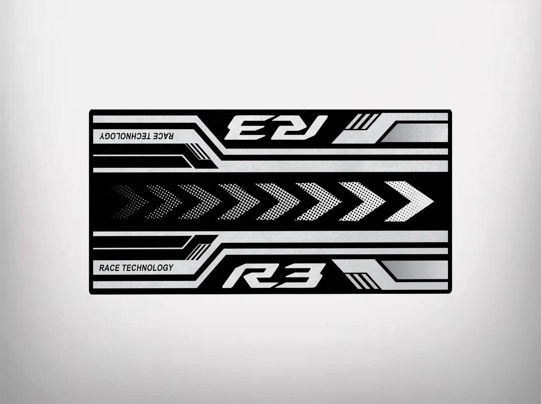 Rectangular black and gray chevron-patterned mat by Motorcycle Pit Mat, designed as a Yamaha R3 2025 Motorcycle Garage Mat. Features mirrored R3 text on top and R3 Race Technology at the bottom, with geometric lines enhancing its dynamic style.