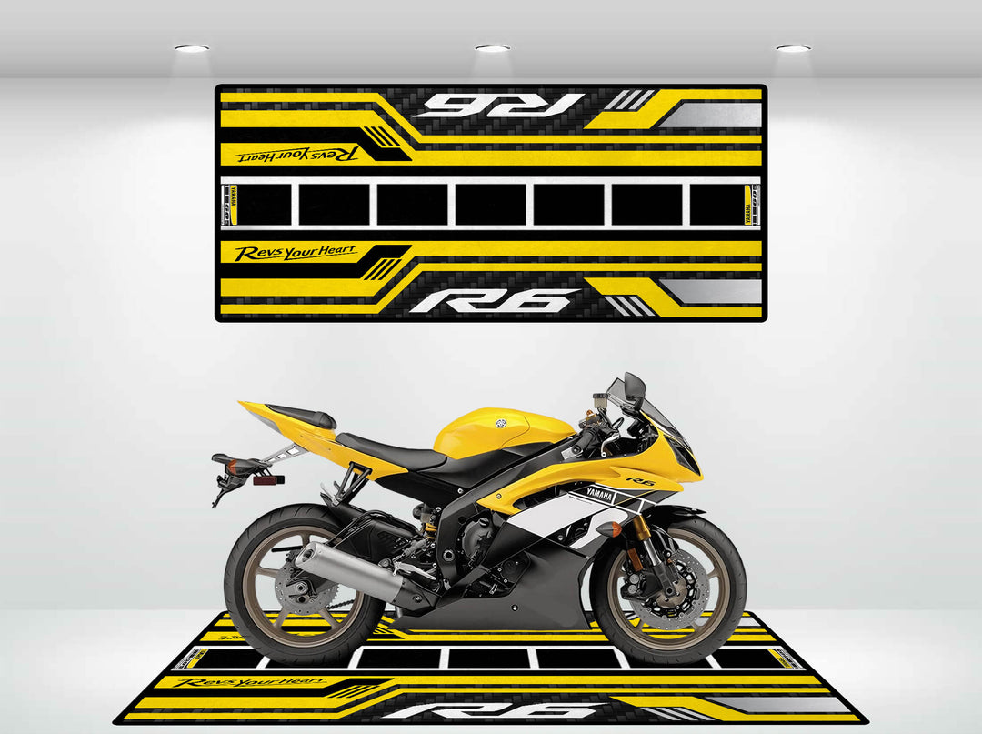 A yellow and black sports motorcycle is parked on a matching Yamaha R6 60th Anniversary motorcycle mat. The backdrop mirrors the mats colors and patterns, with both showcasing the model label R6, emphasizing the cohesive design.