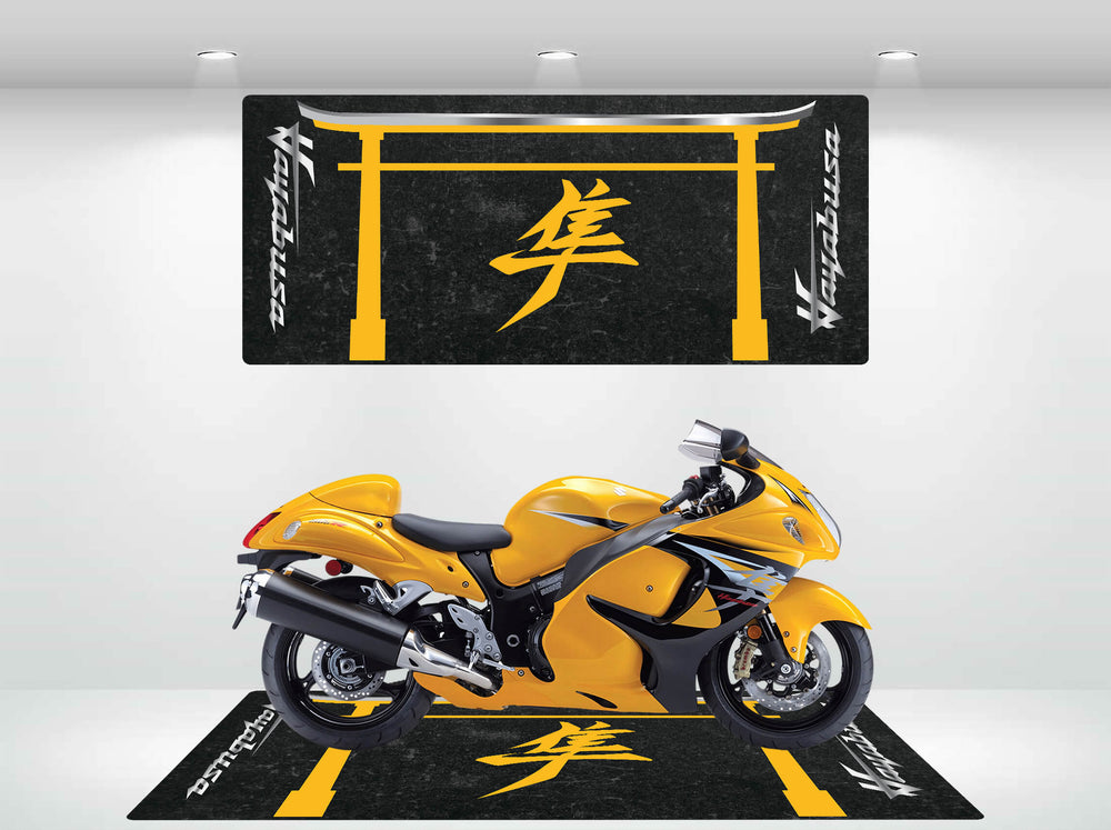 A yellow sports motorcycle stands on the Motorcycle Pit Mat for Suzuki Hayabusa, featuring black and yellow hues with Japanese characters. The matching wall design above is vividly lit by bright overhead lights.