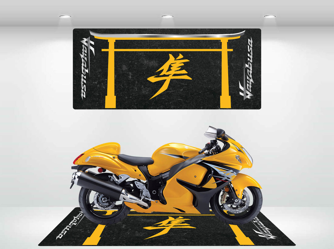 A yellow sports motorcycle stands on the Motorcycle Pit Mat for Suzuki Hayabusa, featuring black and yellow hues with Japanese characters. The matching wall design above is vividly lit by bright overhead lights.